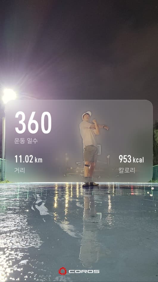 비에 젖은 야간 운동장 위로 11.02km 거리와 953kcal 기록이 표시된 코로스 사진