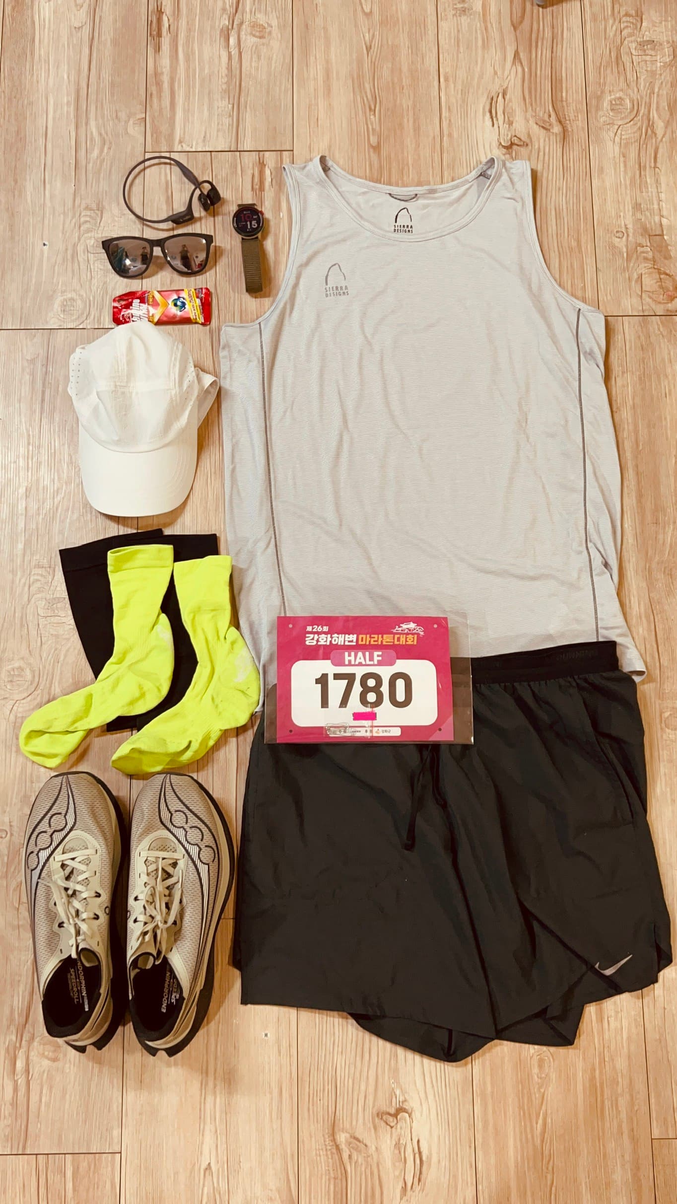 Running clothes and gear laid out on the floor for the Ganghwa Beach Marathon half
